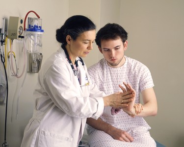 Doctor examining the hand of a patient.
